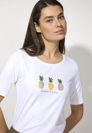 Weißes T-Shirt mit kurzen Ärmeln, das ein Druckdesign von drei Ananas und dem Text "sweet & juicy" in Grün und Gelb zeigt. Rundhalsausschnitt.