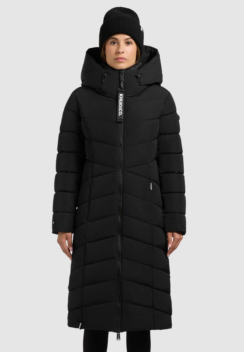 Zwarte pufferjas met een ritssluiting aan de voorkant, een hoge kraag en een capuchon. Heeft chevronsteek en zijzakken. Inclusief een logo-label bij de nek.