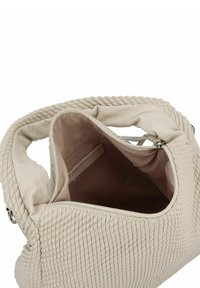 Sac en cuir tissé beige avec un dessus ouvert, présentant un extérieur texturé et un intérieur doux, mettant en valeur un espace intérieur spacieux avec une poche latérale.