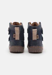Navy blauwe hoge schoenen van glad en gemarmerd leer, met klittenbandsluitingen en bruine rubberen zolen; met het merklogo op de hiel.
