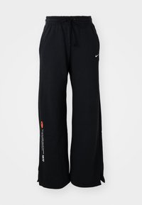 Schwarze Jogginghosen aus Baumwolle, mit einem verstellbaren Bund, seitlichen Schlitzen am Saum und kontrastierendem orange- und weißen Text auf einem Bein.