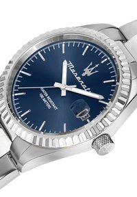 Silver stainless steel watch with a blue dial, silver hour markers, and date display. Features a textured bezel and a knurled crown.