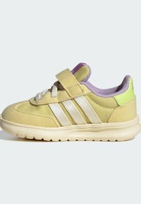 Yellow athletic shoe with a soft suede finish, featuring white stripes, a purple ankle collar, and a Velcro strap.