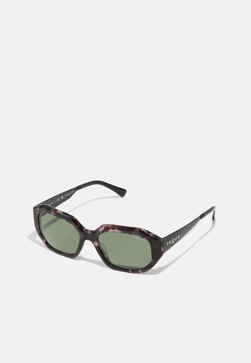 Ochelari de soare tortoise maro cu lentile polarizate verzi, cadru dreptunghiular și brațe negre cu cuvântul "vogue" în alb.