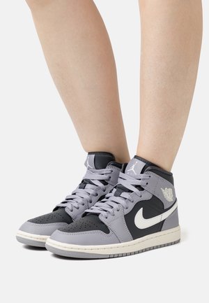 High-top sneakers with a black and gray leather upper. Features include perforated toe box, gray laces, and white Nike Swoosh logo.