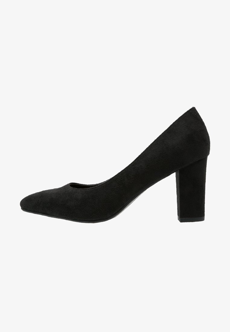 Escarpin noir en daim à talon haut avec un bout rond et un talon bloc épais, vu de côté sur fond blanc.