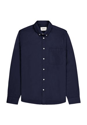 Chemise à manches longues bleu marine en coton. Elle possède un col boutonné, des boutons blancs et une poche poitrine unique du côté gauche.