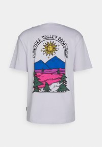 Tricou alb din bumbac cu un design grafic colorat care ilustrează un soare, munți și copaci, având textul "Pinetree Valley Basecamp" în partea de sus.