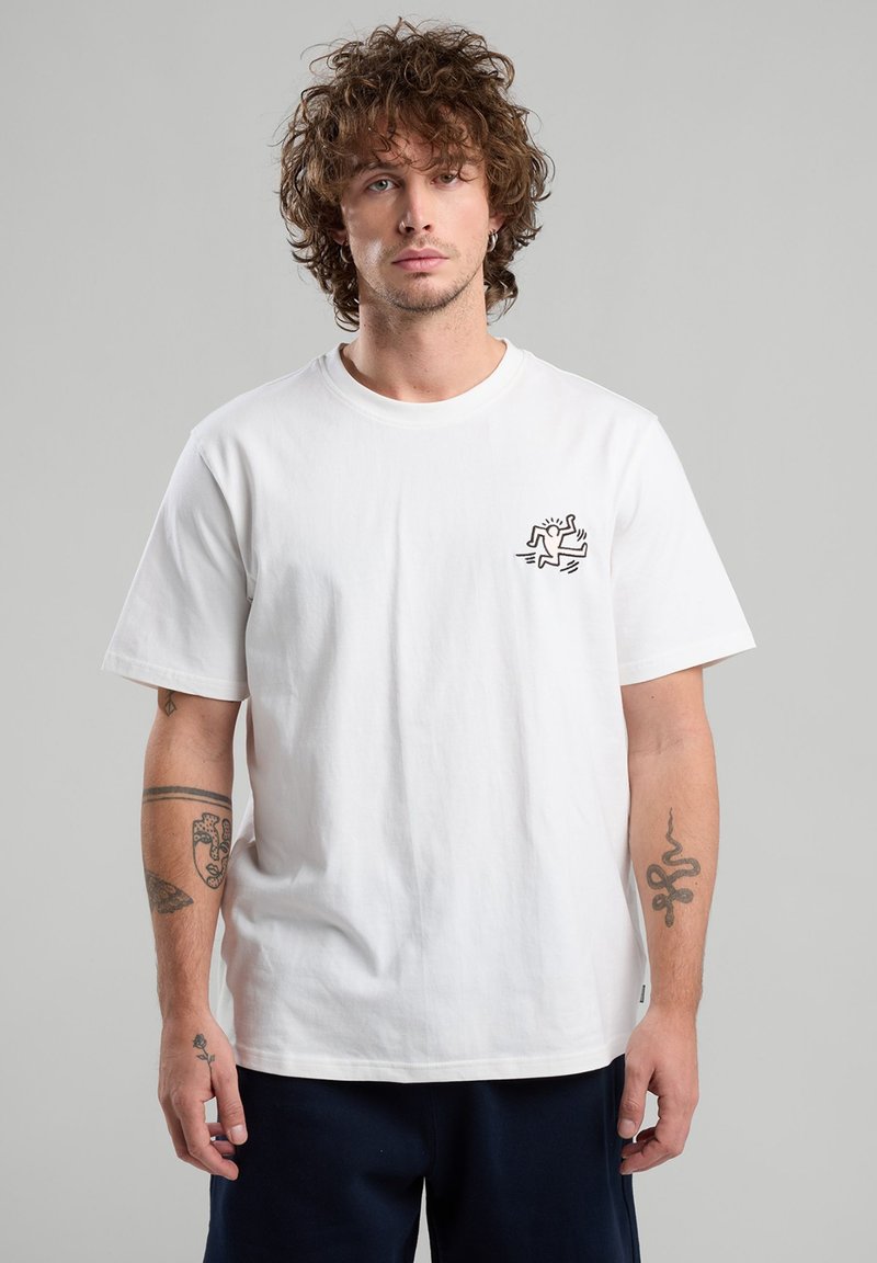 White cotton t-shirt with a round neck and short sleeves. Features a black graphic design on the left chest. Smooth texture.