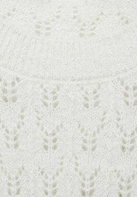 Biały dzianinowy materiał z teksturowanym wzorem liści, o miękkim i puszystym wyglądzie, zaakcentowany subtelnymi metalicznymi nitkami.