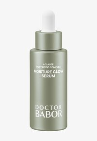 Flacon en verre vert avec un compte-gouttes et un capuchon blanc, étiqueté "Sérum Éclat d'Hydratation," avec des textes détaillant les ingrédients et le nom de la marque.