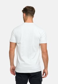 Maglietta bianca in cotone a maniche corte, con collo rotondo e schiena semplice. Presenta un orlo dritto e una texture morbida.