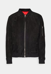 Giacca bomber nera in suede con chiusura a zip frontale, polsini e orlo a costine, e un interno rosso a contrasto. Presenta tasche laterali e sulle maniche.