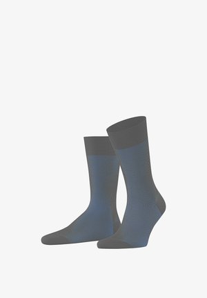 Grijze geribbelde sokken met blauwe accenten, tot halverwege de kuit, met een gladde textuur en een contrasterend kleurblok bovenaan.