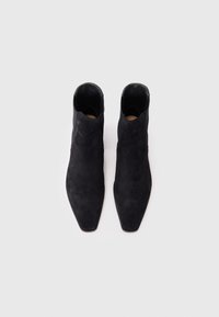 Sorte semska ankelstøvler med spiss tupp og glatt tekstur. Har et lavt design og minimalistisk stil. Ingen synlig maskinvare.
