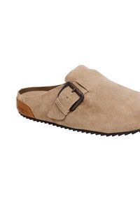 Μπεζ σουέτ κλειστό παπούτσι τύπου clog με ρυθμιζόμενο μαύρο πόρπη και καφέ δερμάτινη λεπτομέρεια στη φτέρνα, με ανάγλυφη μαύρη σόλα.