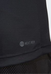 Tessuto atletico nero con superficie texture, caratterizzato da un piccolo logo grigio "HEAT.RDY". L'orlo inferiore è liscio e presenta un pannello in mesh.