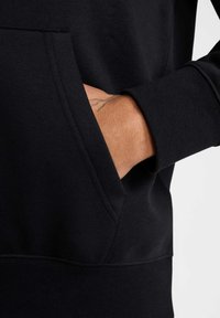 Felpa nera con cappuccio, caratterizzata da una tasca frontale, polsini a coste, texture liscia e dettagli di cucitura in evidenza.