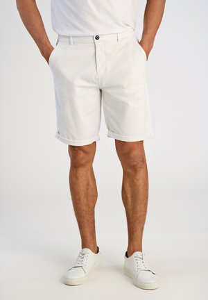 White cotton shorts with rolled cuffs, featuring a button closure and side pockets, paired with white sneakers on a plain background.