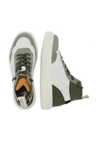 Sneakers alte con una toma in pelle bianca, accenti verde oliva, suola testurizzata e lacci rotondi. Presentano una linguetta imbottita color cuoio e dettagli cuciti.