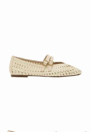 Chaussure plate tissée beige avec des brides à double boucle et un talon bas, présentant un motif en treillis ouvert sur la tige.
