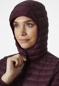 Burgundská péřová bunda s těsně padnoucí kapucí, prošívanou strukturou a zipovým zapínáním. Měkký materiál s vyvýšenými švy a elastickými akcenty.