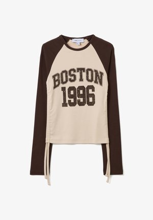 Sudadera de manga larga con mangas raglán marrones, cuerpo beige y un gráfico frontal que dice "BOSTON 1996" en una fuente negra en negrita con un diseño moteado.