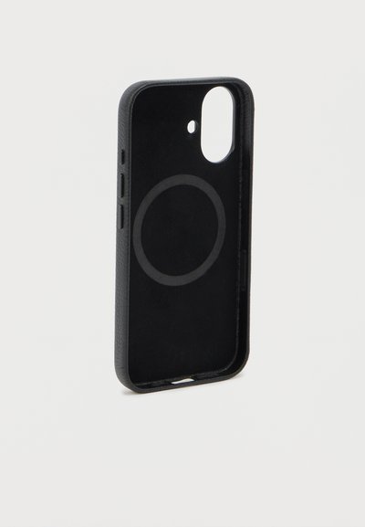 Μαύρη θήκη smartphone με κυκλικό χώρο φόρτισης MagSafe και ανοιγματάκια για τα κουμπιά, όρθια σε λευκό φόντο.