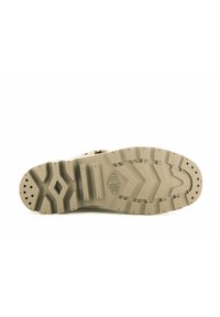 Brun gummisula med strukturerade mönster och dämpande spår, designad för grepp och hållbarhet. Har en logotypavtryck.