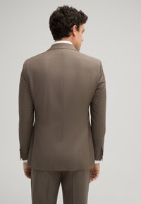 Brauner maßgeschneiderter Blazer mit glatter Textur, ausgestattet mit Reverskragen und geknöpften Manschetten, von hinten betrachtet, kombiniert mit passenden Hosen.