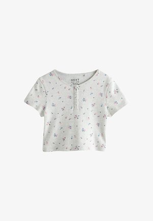 Camisa corta de manga corta en gris claro con estampado pequeño de flores rosas y azules y una tapeta de cuatro botones en el escote frontal.