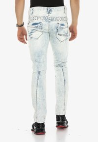 Hellblau gewaschene Denim-Jeans mit schmaler Passform, ausgestattet mit zwei Gesäßtaschen, Logo-Details am Bund und subtilen Waschungen.