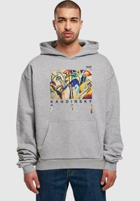 Felpa grigia con tasca frontale, caratterizzata da una stampa artistica colorata di Kandinsky centrata sul petto. Vestibilità comoda con polsini e orlo a coste.