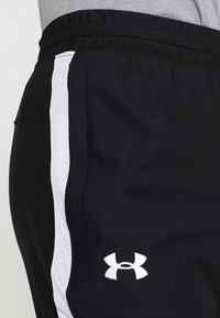Schwarze Sportshorts mit weißem Mesh-Einsatz an der Seite, elastischem Taillenbund und gesticktem Logo am unteren Bein.