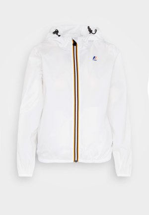 Veste légère blanche avec capuche, dotée d'une fermeture éclair à l'avant avec une bande noire, jaune et rouge au centre et des poignets élastiques.