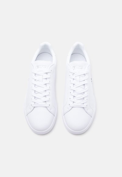 Ζευγάρι λευκά δερμάτινα sneakers χαμηλού λοξού με κορδόνια, από πάνω, σε απλό ανοιχτό γκρι φόντο.