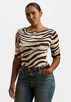 Tett kortermet topp med tigermønster i beige og brunt. Kombinert med høyt liv, falmet denim og et brunt belte med gullspenne.