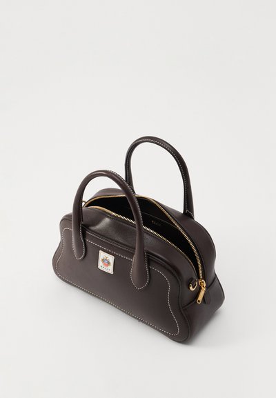 Sac à main en cuir marron, de forme arrondie. Comprend une fermeture éclair dorée, des poignées doubles, des coutures blanches et un patch logo décoratif à l'avant.