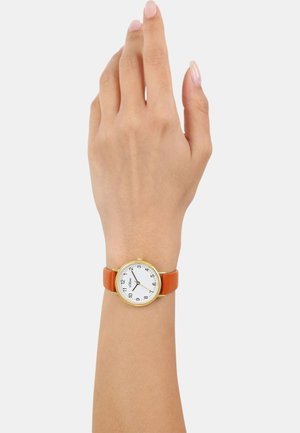 Runde Uhr mit einem weißen Zifferblatt, goldfarbener Lünette, schwarzen Ziffern und orangen Lederarmband, getragen an einer Hand.