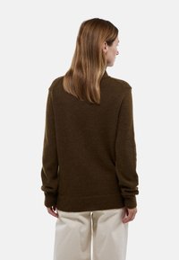 Pull en laine marron avec une coupe décontractée, des poignets et un ourlet côtelés. Présente un col rond et une texture douce, vu de dos.