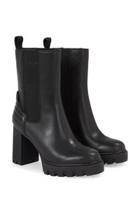 Czarne skórzane botki za kostkę z elastycznymi panelami bocznymi, blokowym obcasem i masywną gumową podeszwą. Posiadają żebrowane akcenty na obcasie.