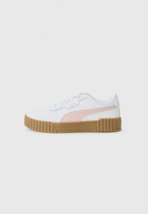 Hvide sports sneakers med en pink detalje og en struktureret tan gummisål, der har en rund tå og snørelukning.