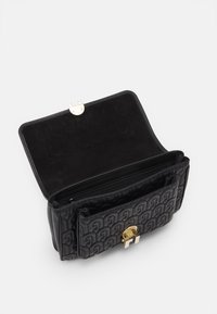 Borsa in pelle nera con motivo trapuntato, caratterizzata da una chiusura in oro. L'interno è foderato in tessuto nero e include una tasca con cerniera.