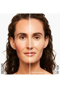 Voor en na vergelijking van een gezicht met krullend, donker haar. De linkerkant toont roodheid; de rechterkant heeft een egale huidtint met het label "260 Cashmere."