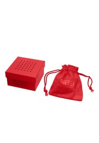 Scatola di cartone rossa con coperchio perforato, con il logo "DIESEL"; accompagnata da un sacchetto in velluto rosso con coulisse e logo abbinato.