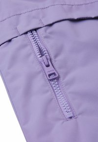 Fioletowy materiał z zamkiem błyskawicznym o gładkiej teksturze. Zamek jest równo z szwem, z małym, markowym uchwytem ułatwiającym dostęp.