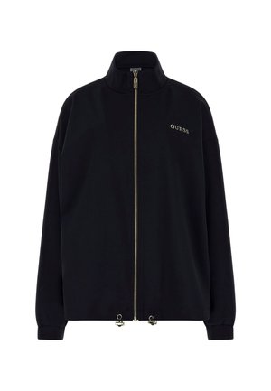 Black zip-up jacket with a high collar. Features a gold zipper and "GUESS" logo in gold stitching on the front. Loose fit with cuffed sleeves.