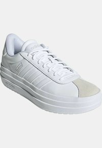 Sneaker bianco con tomaia in pelle liscia e punta in suede, caratterizzata da tre strisce testurizzate e una suola spessa e imbottita.