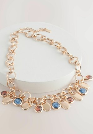 Halsband i guldton med kedja som har cirkulära länkar och 10 dekorativa hängen. Blandade ädelstenskänsliga färger inkluderar blå och rödbruna accenter.