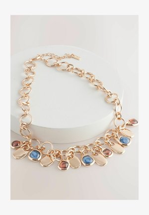 Kuldtooni ahelkaelake, millel on ringikujulised lingid ja 10 dekoratiivset ripatsit. Segatud gemitaolised värvid, sealhulgas sinised ja pruunikirjud aktsendid.